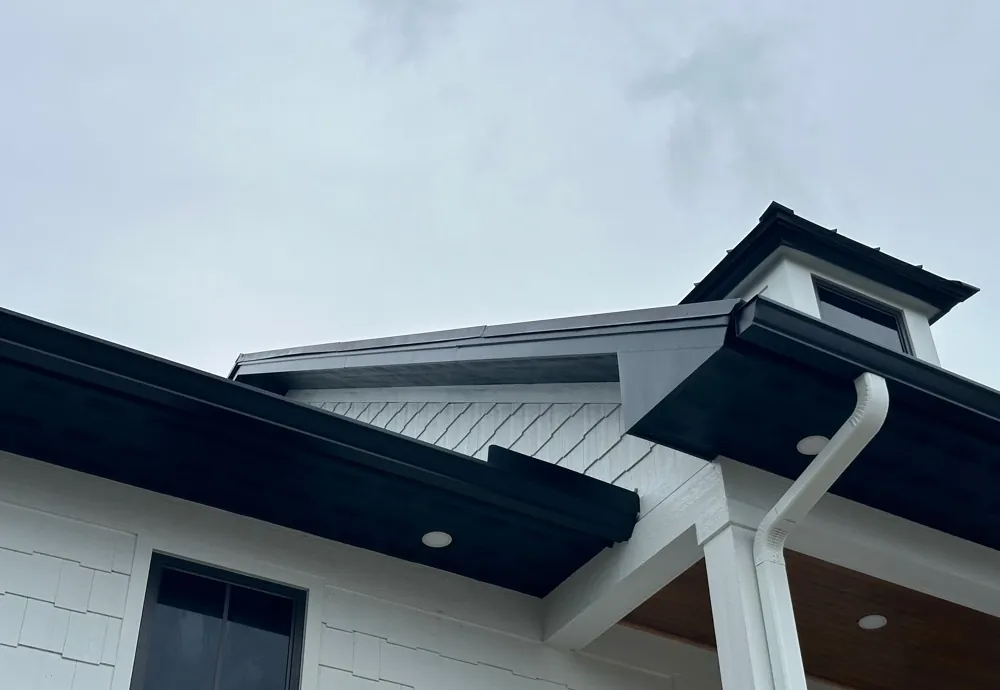 Black gutters with a white downspout on a shake-siding home in Sanibel, FL