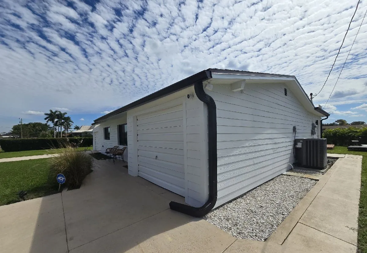 Black gutters and downspout on a white-sided garage in North Fort Myers, FL