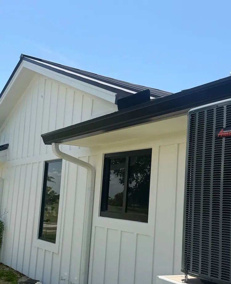 White board-and-batten home with dark bronze gutters in Sanibel, FL