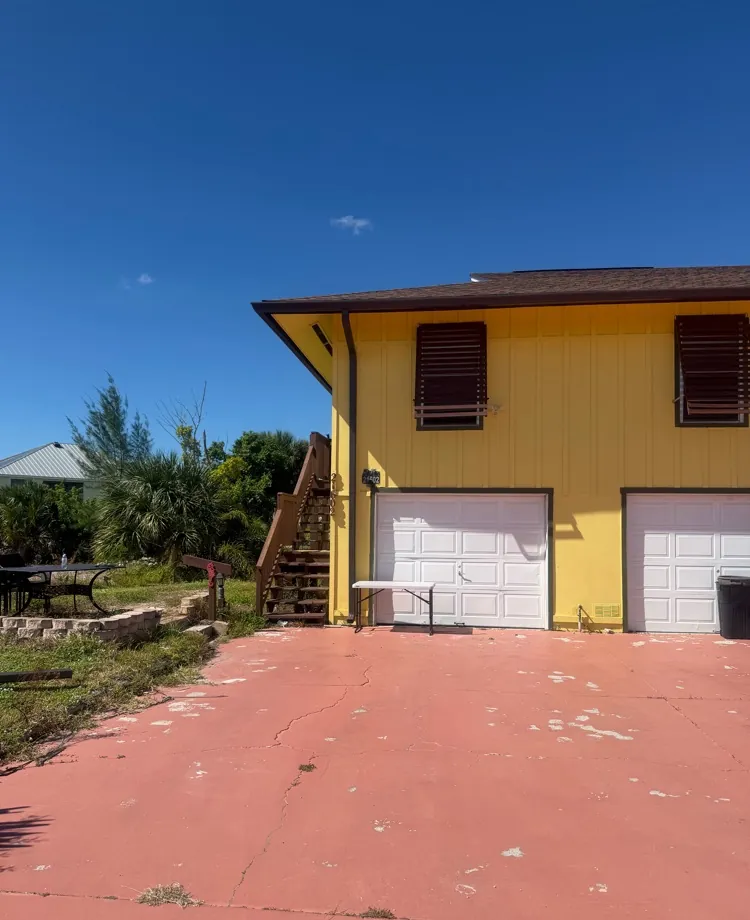 Yellow raised home with dark bronze gutters in Fort Myers Beach, FL