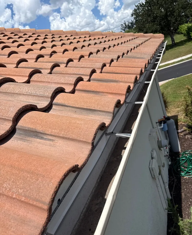 Hidden hangers added to re-secure a gutter under a tile roof in Fort Myers, FL
