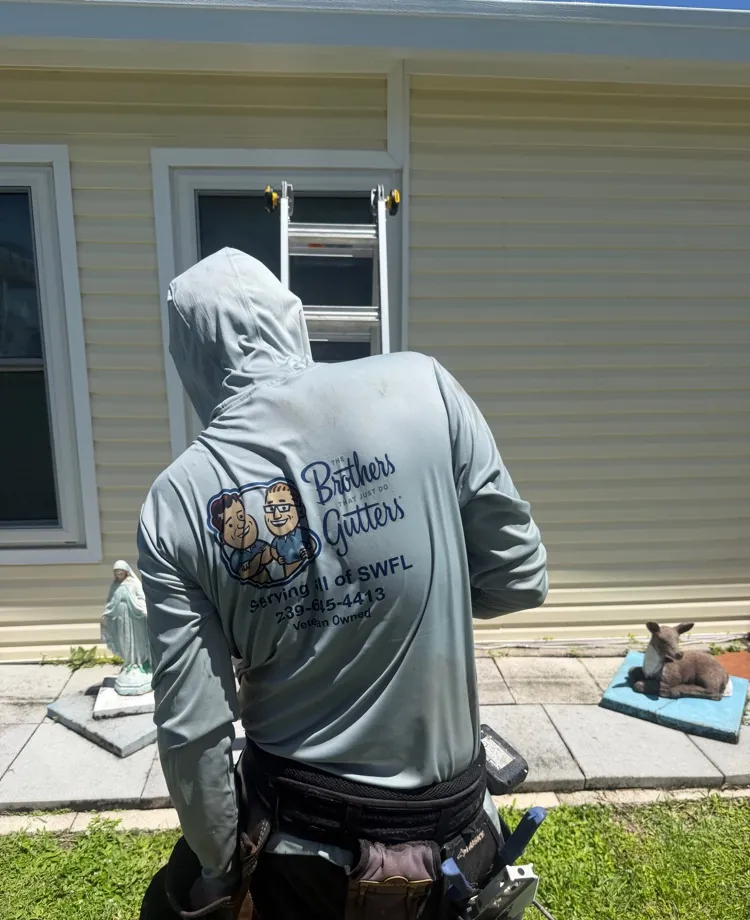 Brothers Gutters installer in a branded work shirt and tool belt on a job in North Fort Myers, FL