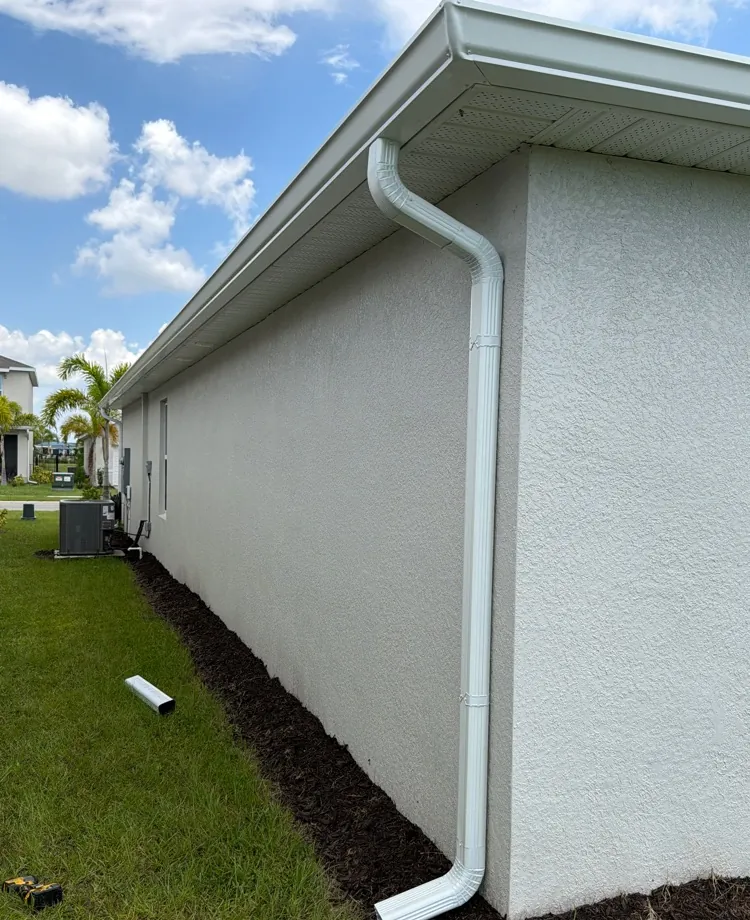 White downspout on a stucco wall in North Fort Myers, FL