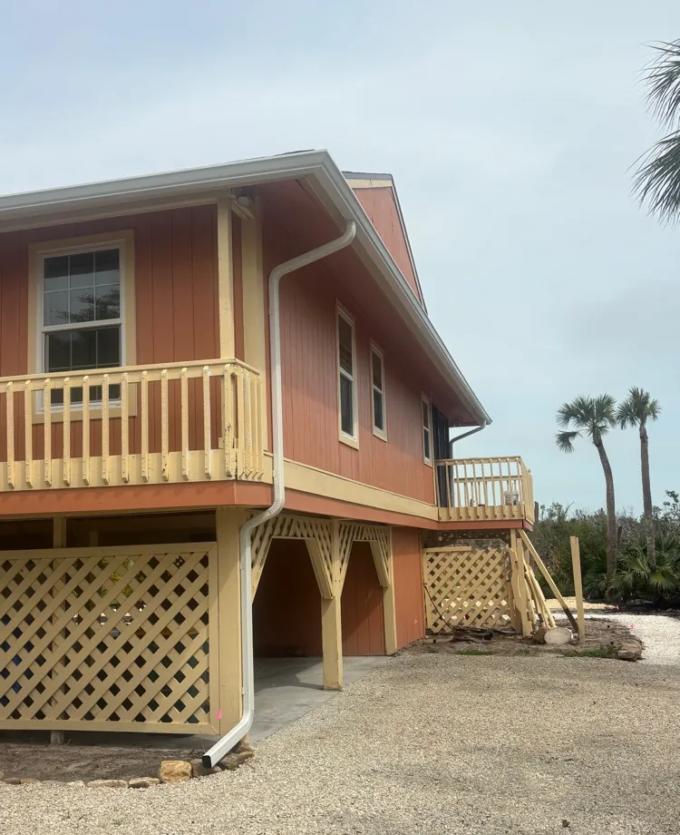 Coral elevated home with white gutters and downspout in Sanibel, FL