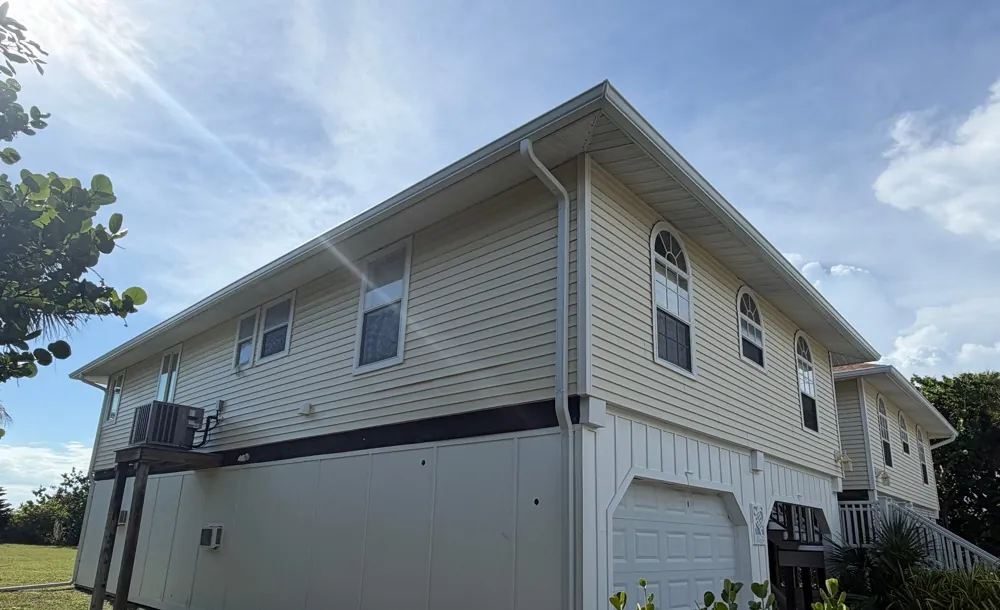 Cream two-story home with white gutters in Sanibel, FL