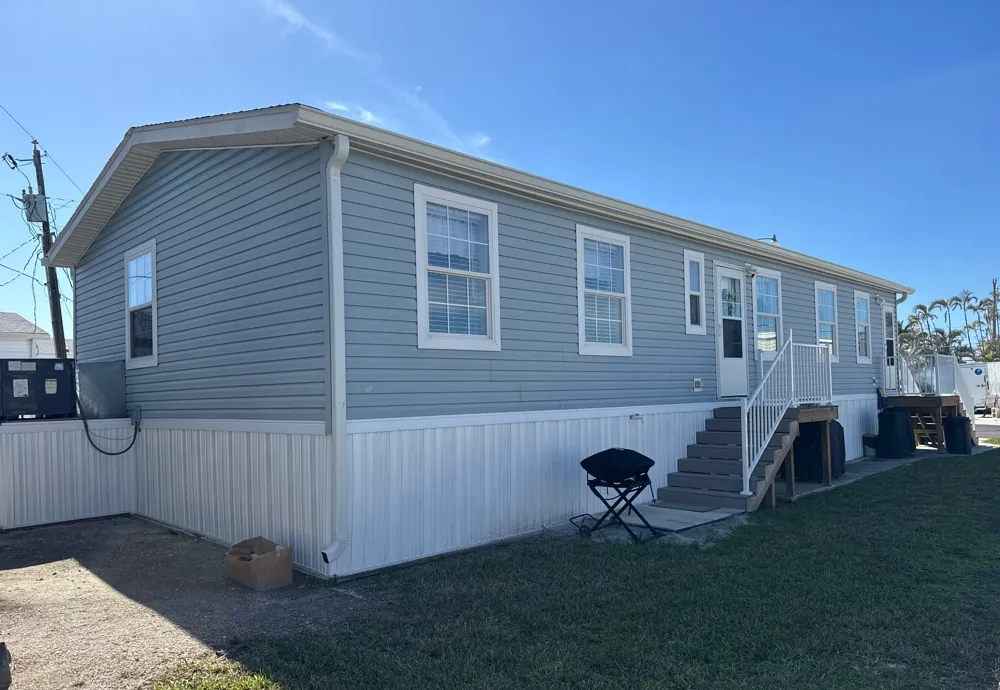 Gray manufactured home with white gutters in Fort Myers Beach, FL