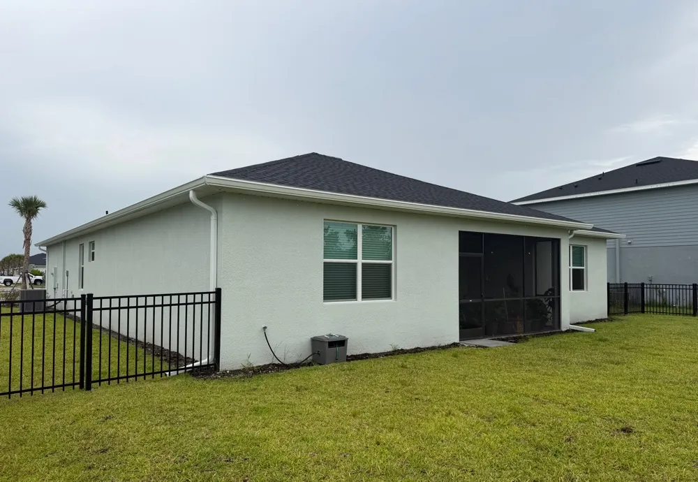 Rear of a gray stucco home with white gutters in North Fort Myers, FL